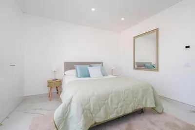 a white bedroom with a bed and a mirror at Talia Lux - two-bedroom luxury apartment by HD in Vilamoura