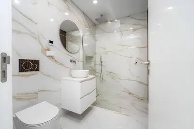 a white bathroom with a toilet and a sink at Talia Lux - two-bedroom luxury apartment by HD in Vilamoura