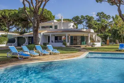 an overhead view of a swimming pool with blue chairs at Joliet in Vilamoura