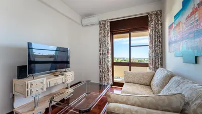 a living room with a couch and a flat screen tv at Cosy 3Bdr Flat near University by LovelyStay in Faro
