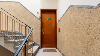 a wooden door in a building with stairs at Cosy 3Bdr Flat near University by LovelyStay in Faro