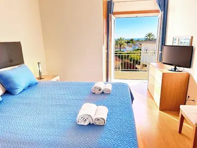 a bedroom with a bed with towels and a television at Balaia Poolside House with Sea View by BeCherish in Atalaia