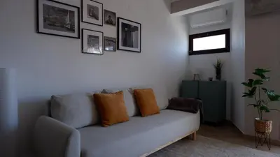 a living room with a gray couch with orange pillows at Pipos d'Al-buhera in Albufeira