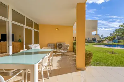 a patio with a table and chairs and a pool at Peaceful 2Bdr with Pool in Vilamoura by LovelyStay in Quarteira