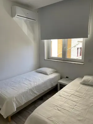 a bedroom with two beds and a window at O&P Apartments in Faro