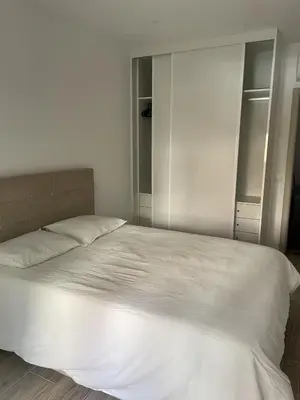 a large white bed in a bedroom with white cabinets at O&P Apartments in Faro