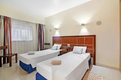 a hotel room with two beds and a window at Paraiso do Atlantico in Albufeira