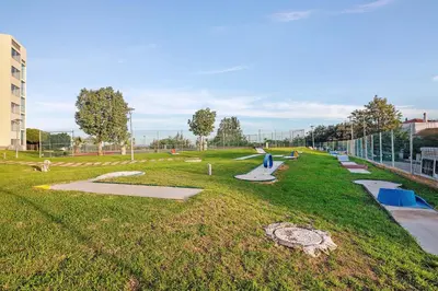 a park with a grassy area with benches and slides at Paraiso do Atlantico in Albufeira
