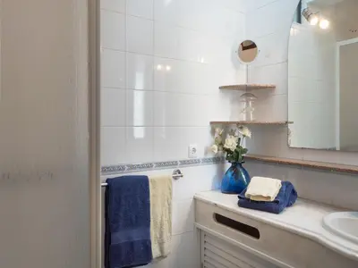 a bathroom with a sink and a vase of flowers at Akivillas Quarteira Cool in Quarteira