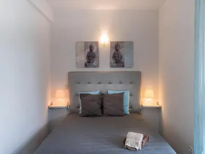 a bedroom with a bed with two pictures on the wall at Akivillas Quarteira Cool in Quarteira