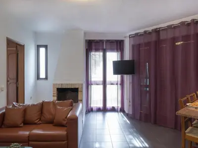 a living room with a brown couch and a fireplace at Akivillas Quarteira Cool in Quarteira