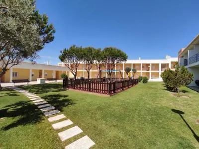 a building with a fence and a grass yard at ABF62 confortavel T2 a 2,5km praia Gale in Galé