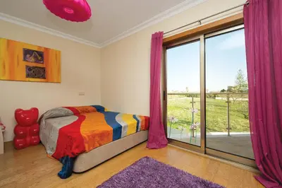 a bedroom with a bed and a large window at ABF38, encantadora Villa V4 em lugar sossegado in Guia