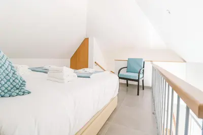 a bedroom with a bed and a blue chair at Faro Old Town Apartments in Faro
