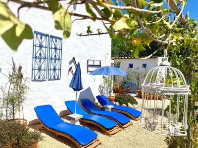 two blue lounge chairs and an umbrella and a bird cage at Holiday Home Vila Primaveira - Nur für Erwachsene by Interhome in Santa Bárbara de Nexe