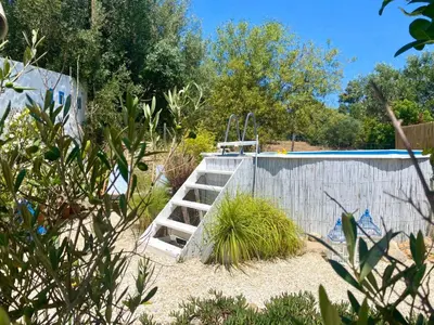 a wooden ladder in the sand next to a pool at Holiday Home Vila Primaveira - Nur für Erwachsene by Interhome in Santa Bárbara de Nexe