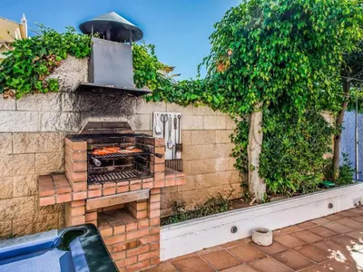 a brick wall with an outdoor grill in a yard at Holiday Home Chalet Villa Oceano mit privatem Pool by Interhome in Albufeira