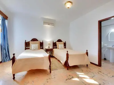 two beds in a white room with a sink at Holiday Home Chalet Villa Albuar mit eigenem Pool by Interhome in Albufeira