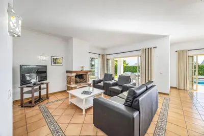 a living room with a couch and a tv and a table at Villa Ventura by Villa Plus in Albufeira