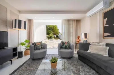 a living room with a couch and chairs and a television at Casa do Gil, Vale do Lobo Beach and Golf in Loulé