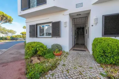 a white house with a gate and bushes at Casa do Gil, Vale do Lobo Beach and Golf in Loulé
