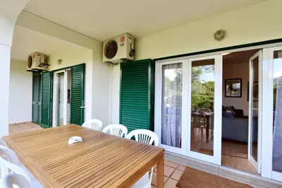a dining room with a wooden table and white chairs at Melias apartment - Cleverdetails, Vilamoura in Vilamoura