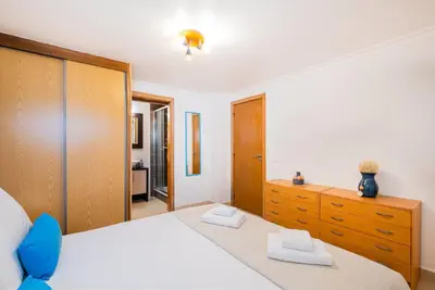 a bedroom with a large bed and a dresser at Margarida Apartment - Ping pong table in Albufeira