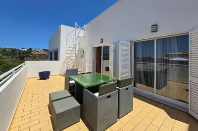 a patio with chairs and an umbrella on a roof at Casa Jokpa Mar Near So Rafael Beach in Albufeira