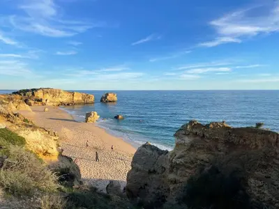 a sandy beach with the sun rising over the ocean at Casa Jokpa Mar Near So Rafael Beach in Albufeira