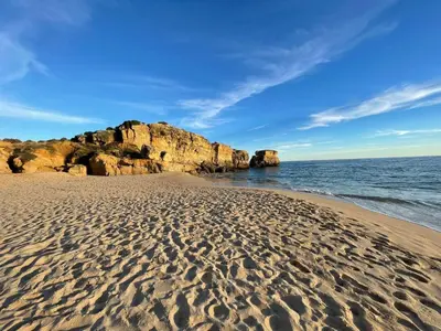 a beach with rocks and footprints in the sand at Casa Jokpa Mar Near So Rafael Beach in Albufeira