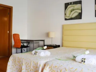 a bedroom with a bed with a table and a chair at Vila Girassol by Stay ici Algarve Holiday Rental in Albufeira