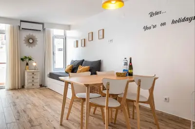 a dining room with a table and chairs and a couch at Rocco del Mar by Portucasa in Albufeira