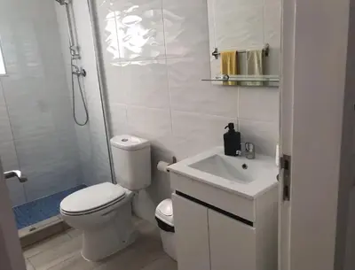 a white bathroom with a toilet and a sink at Blife Delya private rooms at Faro beach in Faro