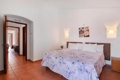 a bedroom with a king sized bed and a desk at Lotus Villa, Albufeira in Albufeira