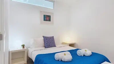 a bedroom with a blue bed with towels on it at Vilamar T0 in Vilamoura