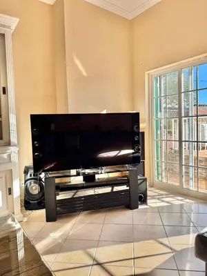 a large flat screen tv on a stand in a living room at Villa Sun & Shine in Faro