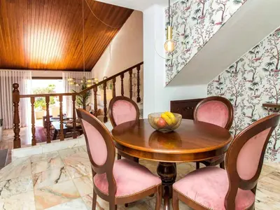 a dining room with a wooden table and pink chairs at Algarve Sun by Stay ici - Algarve Holiday Rental in Albufeira