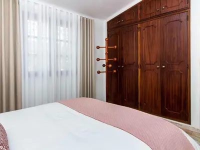 a bedroom with a large wooden cabinet and a bed at Algarve Sun by Stay ici - Algarve Holiday Rental in Albufeira