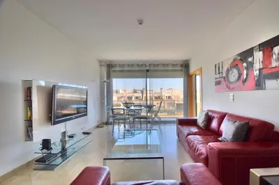 a living room with a red couch and a tv at Vilamoura Aquamar in Quarteira