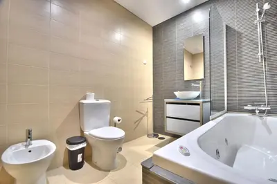 a bathroom with a tub and a toilet and a sink at Vilamoura Aquamar in Quarteira