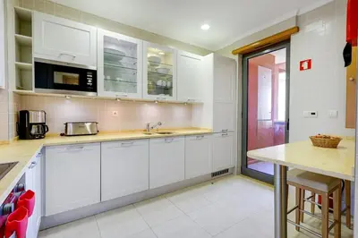 a kitchen with white cabinets and a counter and a mirror at The Prestige @ The Vilamoura Residences in Quarteira