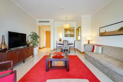 a living room with a couch and a red rug at The Prestige @ The Vilamoura Residences in Quarteira