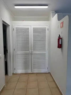 a hallway with white doors and a fire hydrant at Relaxing studio in Albufeira Jardim in Albufeira
