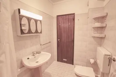a white bathroom with a sink and a toilet at Charming Getaway Apartment in Quarteira in Quarteira