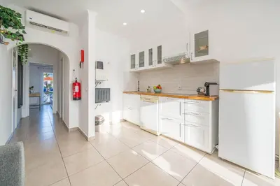 a kitchen with white cabinets and a tile floor at Sunlit Balcony & Open Space Flat by HostWise in Albufeira