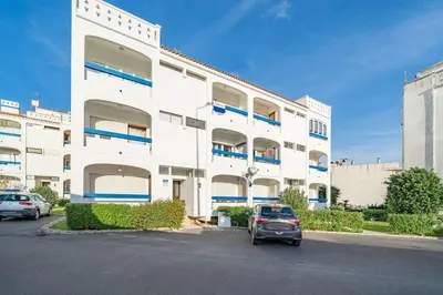 a white building with cars parked in front of it at Sunlit Balcony & Open Space Flat by HostWise in Albufeira