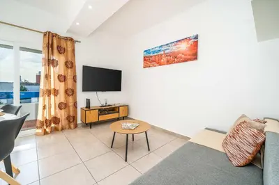 a living room with a couch and a tv at Sunlit Balcony & Open Space Flat by HostWise in Albufeira