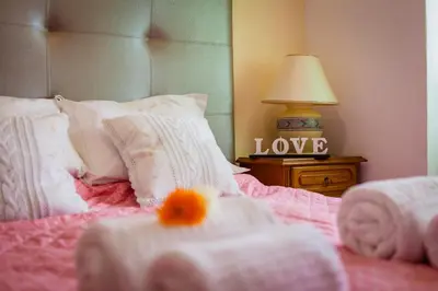 a bedroom with a bed with alove sign on it at Apartamento Cardoso in Albufeira