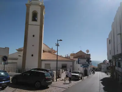 a building with a clock tower next to a street at Apartamento Cardoso in Albufeira