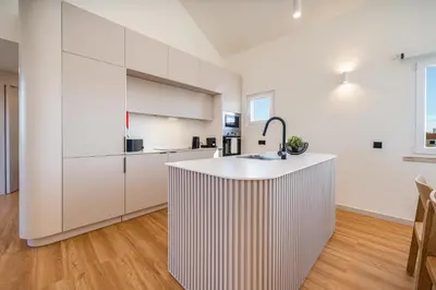 a kitchen with white cabinets and a kitchen island at Marina Búzios Vilamoura Central 2-Bedroom Apartments in Vilamoura